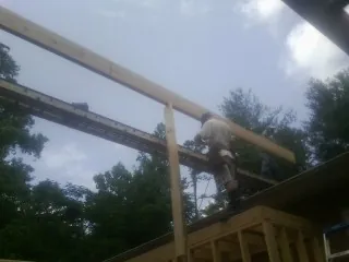 Carpenter setting a ridge beam over a new addition frame — Ice Dam Removal by Roofing Brothers in Bishop