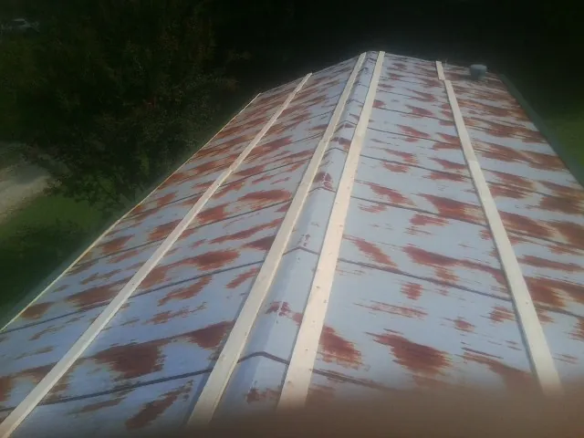 Rusted metal roof panels with new wood purlins before replacement — Storm Damage Roof Repair in Bishop by Roofing Brothers