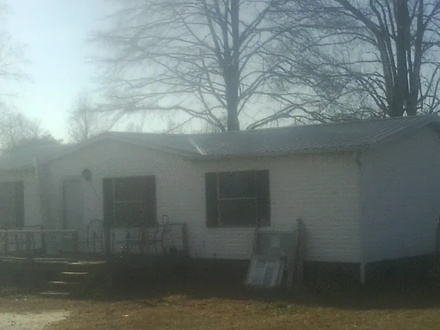 New metal roof on a white painted brick home on a foggy morning in Bishop