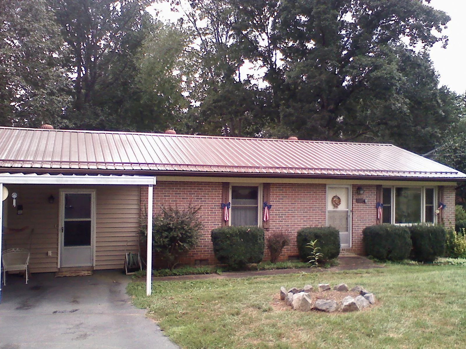 Bronze metal roof and carport on a brick ranch home — Roof Repair work by our crew in Bishop